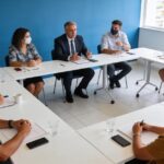 Síndico em reunião com condôminos discutindo direitos e deveres em sala de reuniões.