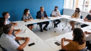 Síndico em reunião com condôminos discutindo direitos e deveres em sala de reuniões.