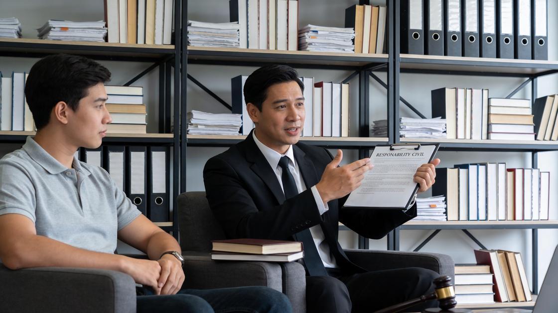 Advogado explicando responsabilidade civil a jovem adulto em escritório moderno, temática importante do artigo.